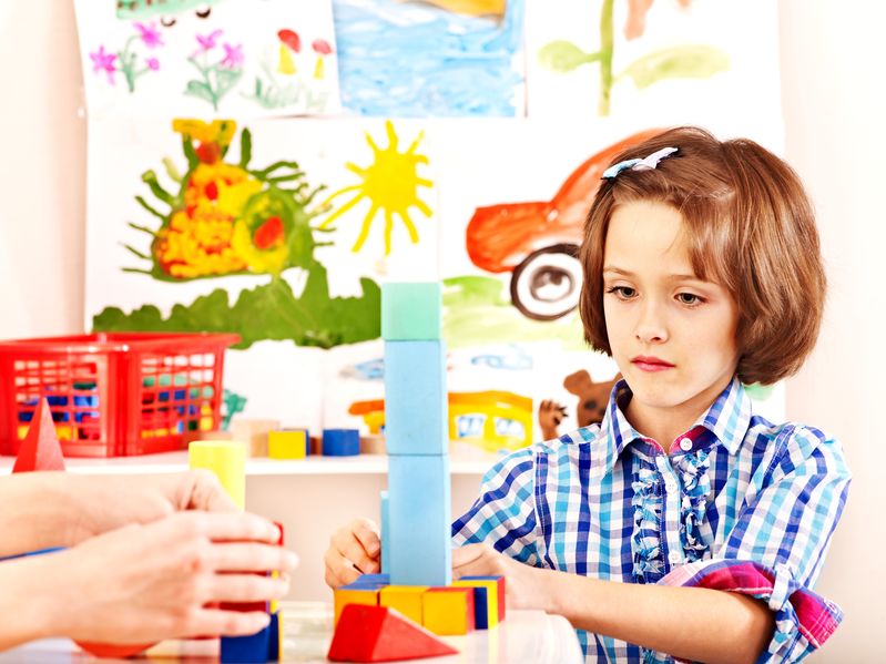 Beautiful Kid playing blocks game at home during lockdown